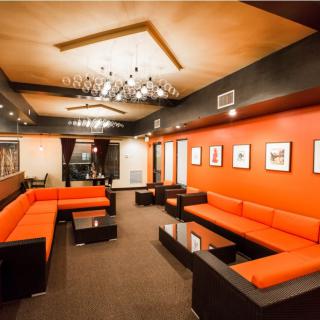 Modern lounge area with vibrant orange seating and stylish lighting.