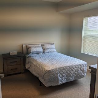 A cozy and minimalistic bedroom with a neatly made bed and soft lighting.