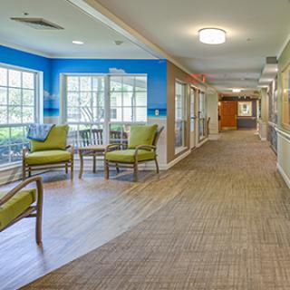 A well-lit hallway with a seating area and large windows.