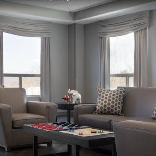 A modern living room with comfortable seating and a coffee table by large windows.