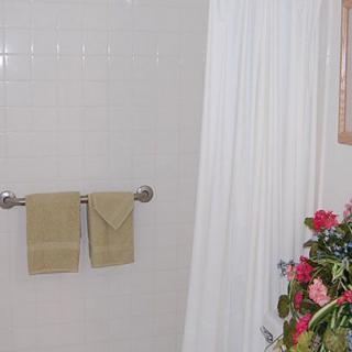 A neatly arranged bathroom with towels and floral decor.