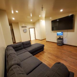 A modern living room with a large sectional sofa and a mounted television.