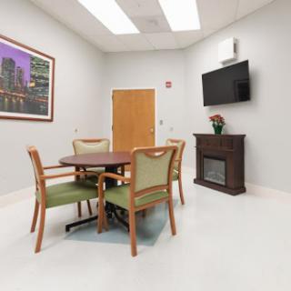 A modern room featuring a dining table and chairs, complete with a television and artwork on the walls.