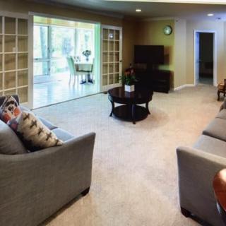 A cozy living room with modern furniture and large windows.