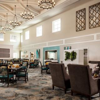 A bright and spacious modern dining area with elegant chandeliers and comfortable seating.