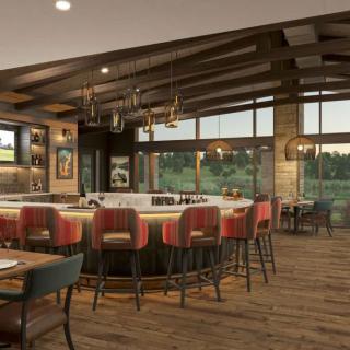 A modern restaurant interior with a central bar and cozy seating area featuring wooden accents and large windows.