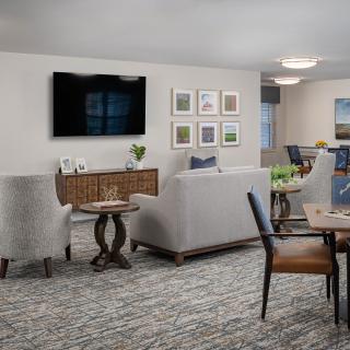 A modern living room with comfortable seating, decorative elements, and a mounted television.