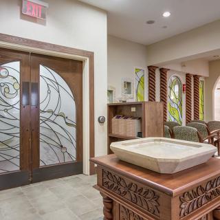 A tastefully designed interior with decorative wooden and glass elements, featuring a waiting area and intricate woodwork.