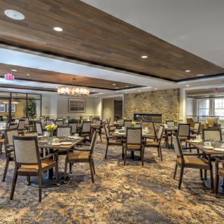 A spacious and elegantly decorated dining area with neatly arranged tables and chairs.
