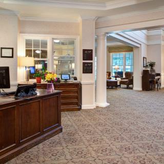A welcoming reception area with a wooden front desk and cozy seating in the background.