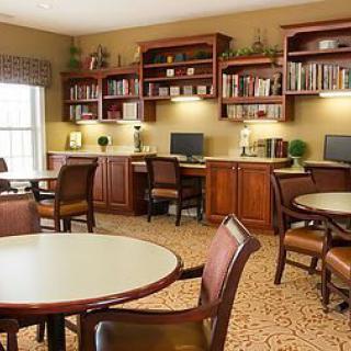 A cozy library with computers, bookshelves, and tables for study or reading.