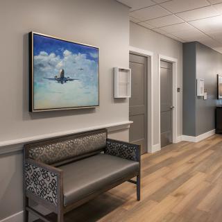 A modern waiting area with seating and artwork on the wall.