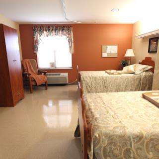 A spacious and inviting bedroom featuring two beds, a comfortable chair, and warm-colored walls.