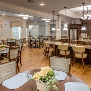 A well-lit and elegantly furnished dining area with wooden floors and comfortable seating.