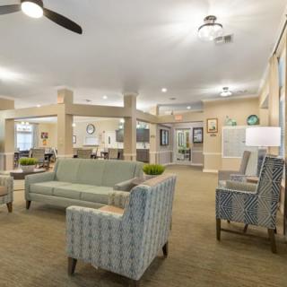A spacious and well-decorated living room with comfortable seating and modern lighting.