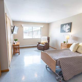 A modern, bright hospital room with clean furnishings and a single bed.