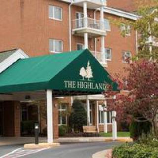 The entrance of a building with green awning labeled 'The Highlands'.