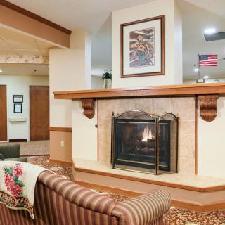A cozy living room featuring a fireplace, comfortable seating, and warm decor.