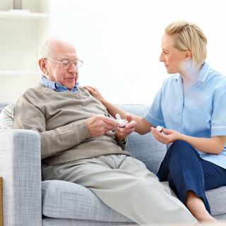 A nurse providing care to an elderly man at home.