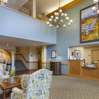A hotel lobby featuring elegant decor with a chandelier, reception desk, and comfortable seating.