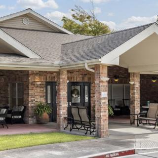 A cozy residential building with a sheltered porch and outdoor seating.