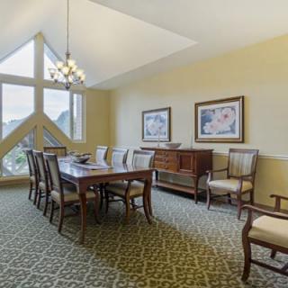 A well-decorated dining room with a wooden table, chairs, and artwork on the walls.