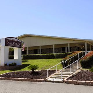 A modern building with a welcoming entrance and landscaped surroundings.