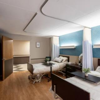 A modern hospital room with two patient beds and a calm, clean atmosphere.