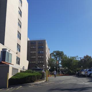 A view of a parking lot beside a building under a clear blue sky.