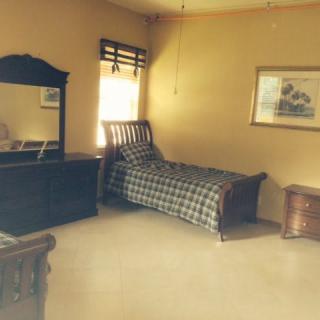 A cozy bedroom with a single bed and wooden furniture.
