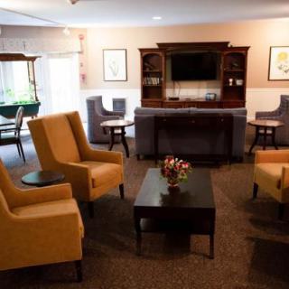 A cozy living room with armchairs, a coffee table, and a television.