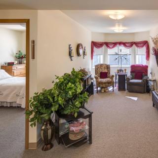 Cozy living room with elegant decor and a view into the adjacent bedroom.