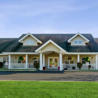 A spacious residential house with a large front porch and well-maintained lawn.