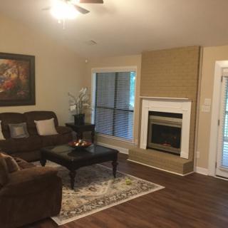 A cozy living room with a brown sofa, coffee table, and a fireplace.