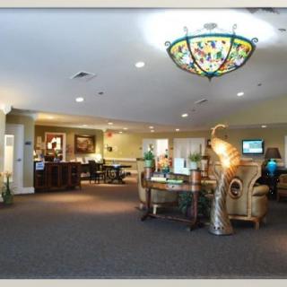 A spacious and elegantly decorated lobby area featuring a reception desk, seating areas, and a decorative chandelier.