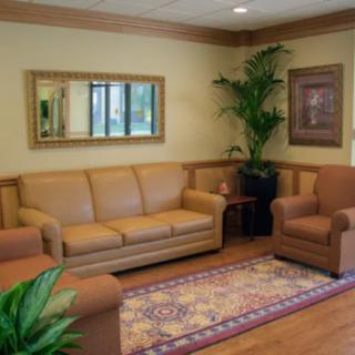 A cozy living room with a sofa, armchair, and decorative elements.
