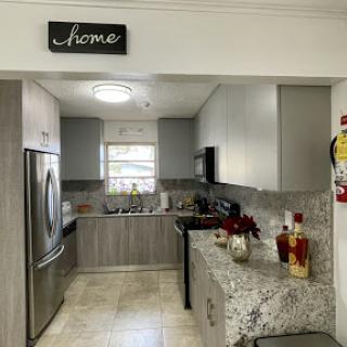 A beautifully designed modern kitchen showcasing sleek grey cabinets and elegant granite countertops.