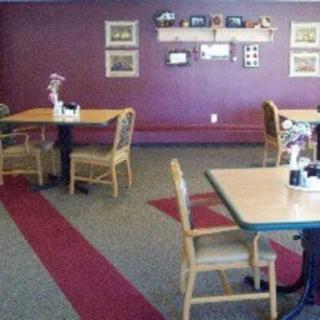 Cozy dining area with tables and chairs, featuring wall decorations.