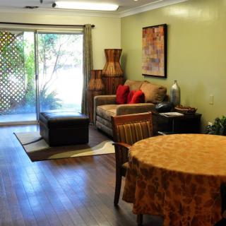 A cozy living room with a sofa, dining table, and sliding glass doors leading to an outdoor area.