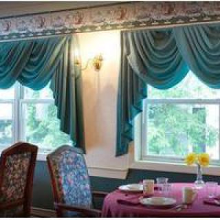 A cozy dining room with elegant teal curtains and a neatly set table.