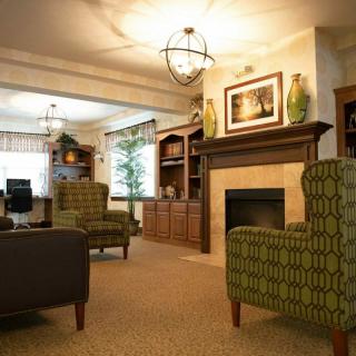 A cozy living room featuring comfortable armchairs, a fireplace, and elegant bookshelves.