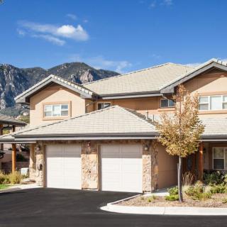 A suburban duplex with garages and a scenic mountain backdrop.
