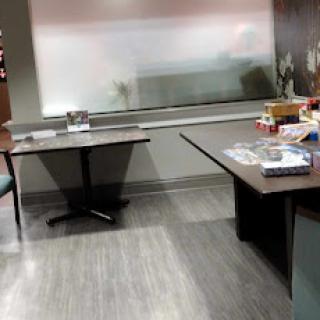 An organized office space featuring two tables and a chair, with natural light streaming through the window.