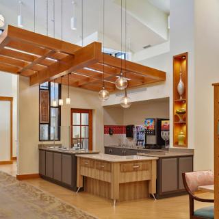 A stylish modern kitchen featuring wooden beams, contemporary lighting, and a spacious layout.