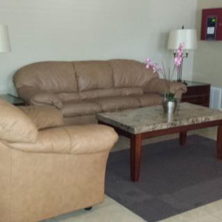 A cozy living room setup featuring a sofa set, a coffee table, and a lamp.