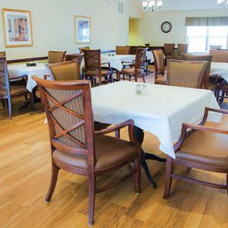 An empty dining room with neatly arranged tables and chairs.