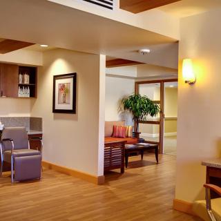 A cozy waiting room with chairs, a small table, and warm lighting.