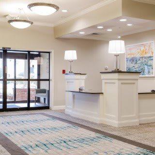 A modern hotel lobby with a reception desk and stylish lighting.