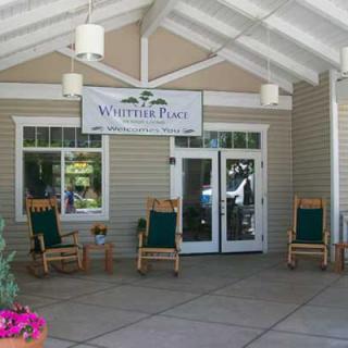 Front entrance with rocking chairs and a sign for Wheel Inn RV Park.