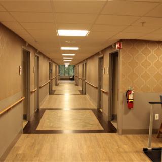 A well-lit hallway featuring doors on either side.